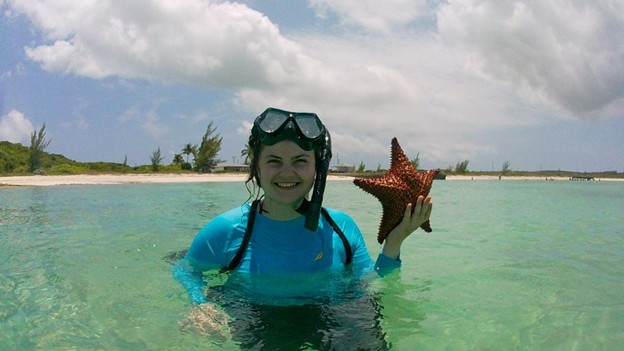 Lindsey Selter wearing a snorkel and holding a starfish in water