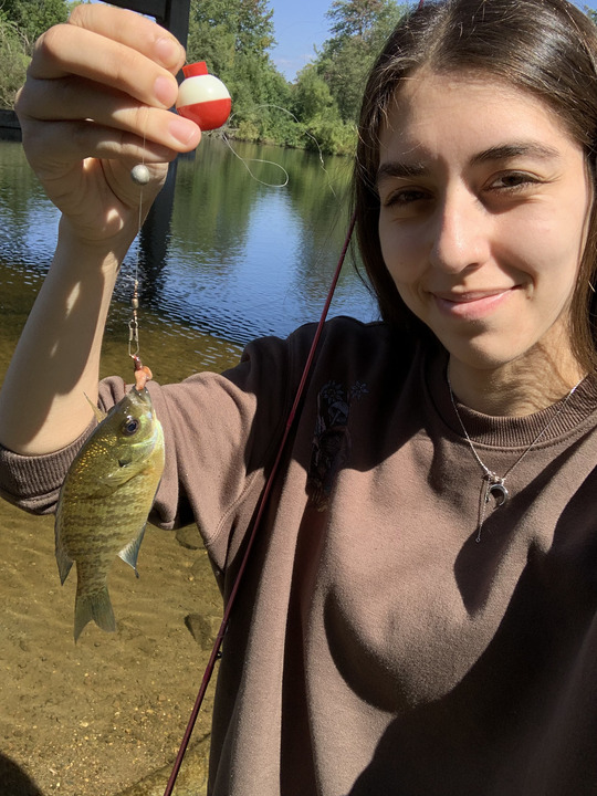 Taleah Nelson holding a small fish attached to a lure